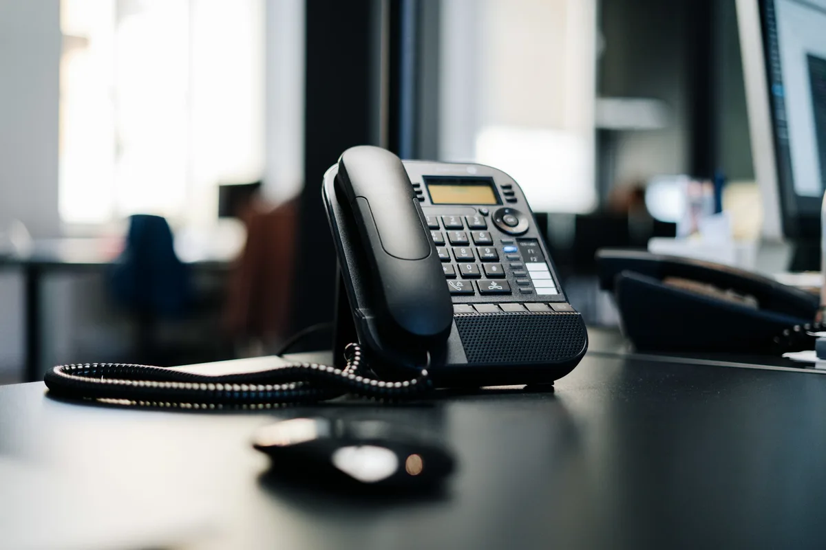 Het bureau bij het raam met de telefoon erop